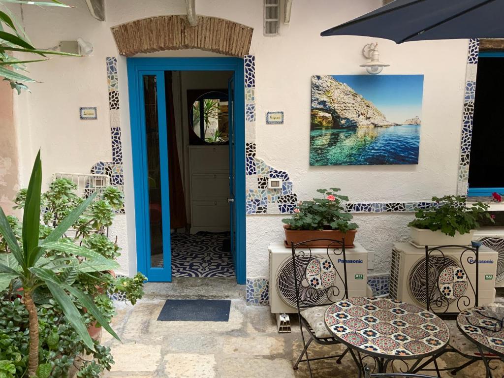 niebieskie drzwi na domu z krzesłami i stołami w obiekcie Cortile Azzurro w Trapani