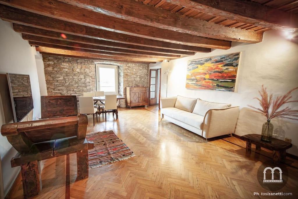 ein Wohnzimmer mit einer Couch und einem Klavier in der Unterkunft Namastè Apartment Città Alta with hills view in Bergamo