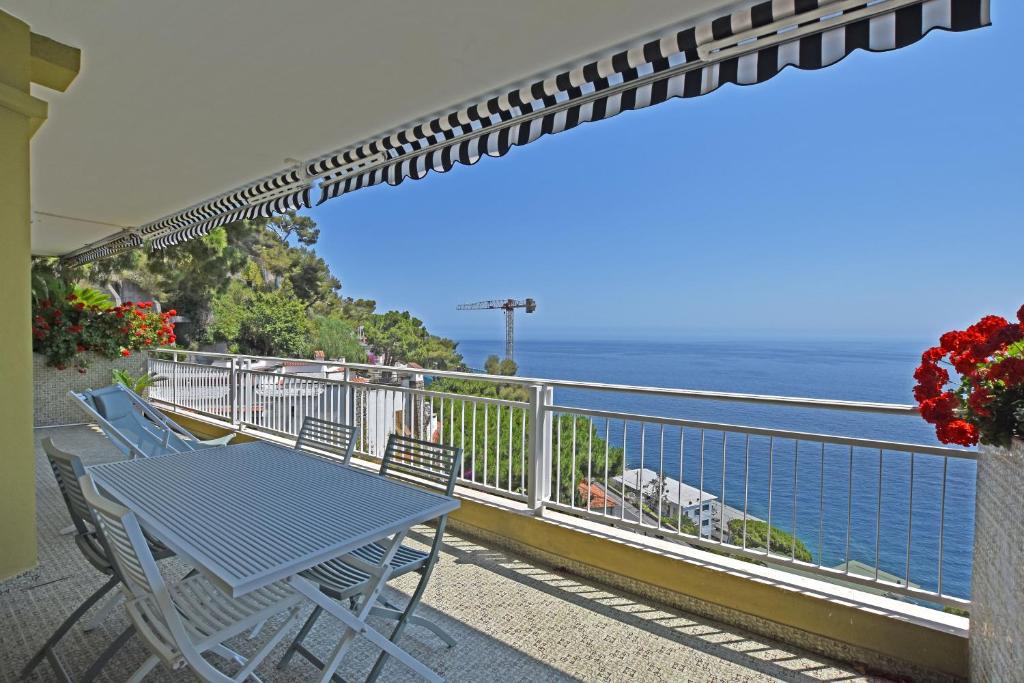 un tavolo e sedie su un balcone con vista sull'oceano di CASA MARGHERITA a Ospedaletti