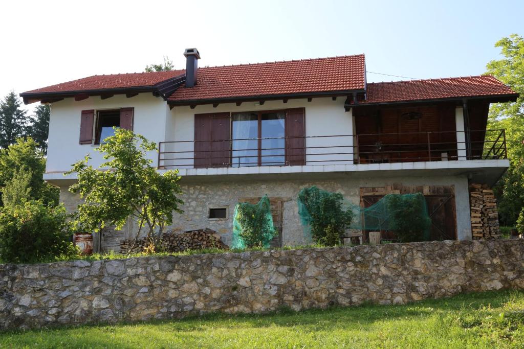 una casa detrás de una pared de piedra en Kuća za odmor Koprivnjak, en Tomaševci
