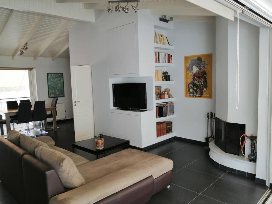 a living room with a couch and a flat screen tv at Manolis Loft in Piraeus
