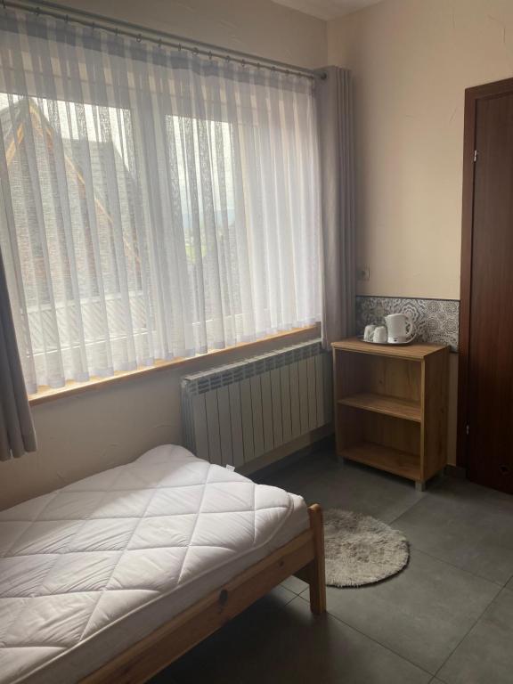 a bedroom with a bed and a window and a table at U Bizioma in Murzasichle