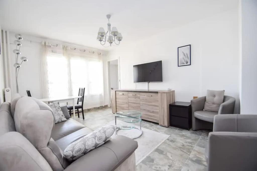 a living room with a couch and a tv and a table at 2 pièces tout confort à Alfortville - chez Christophe in Alfortville