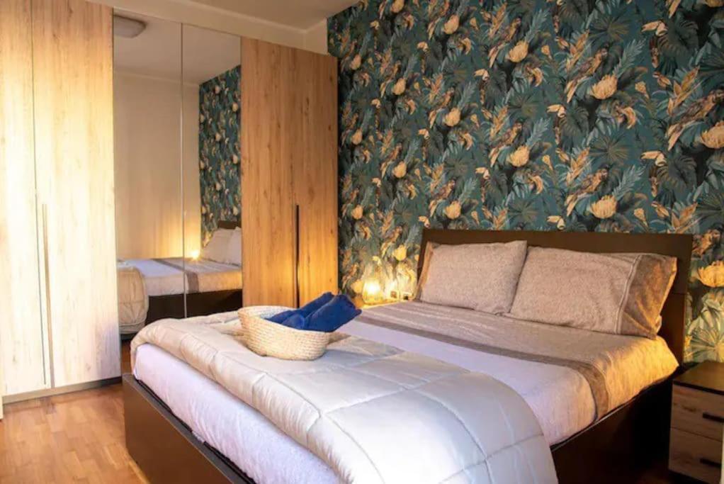 een slaapkamer met een bed met een bloemenmuur bij Exclusive Location in Caserta