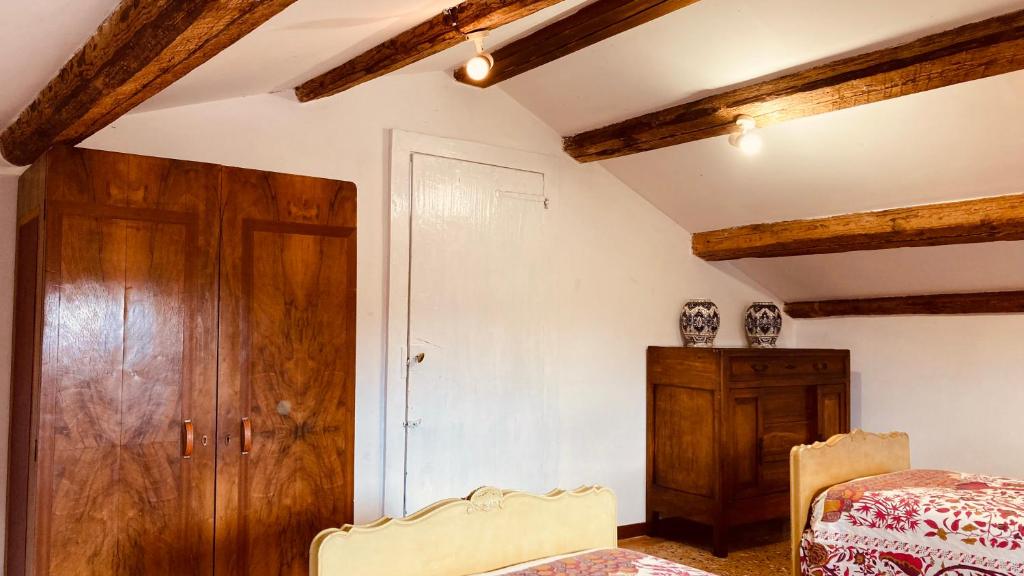 a bedroom with wooden ceilings and a bed and a wooden cabinet at Cà Sardi in Venice