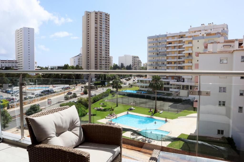 een balkon met een bank en uitzicht op de stad bij Monte da Ondas by ALgest in Portimão