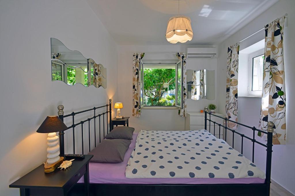 um quarto com uma cama e uma janela em Terrace Apartment em Hvar