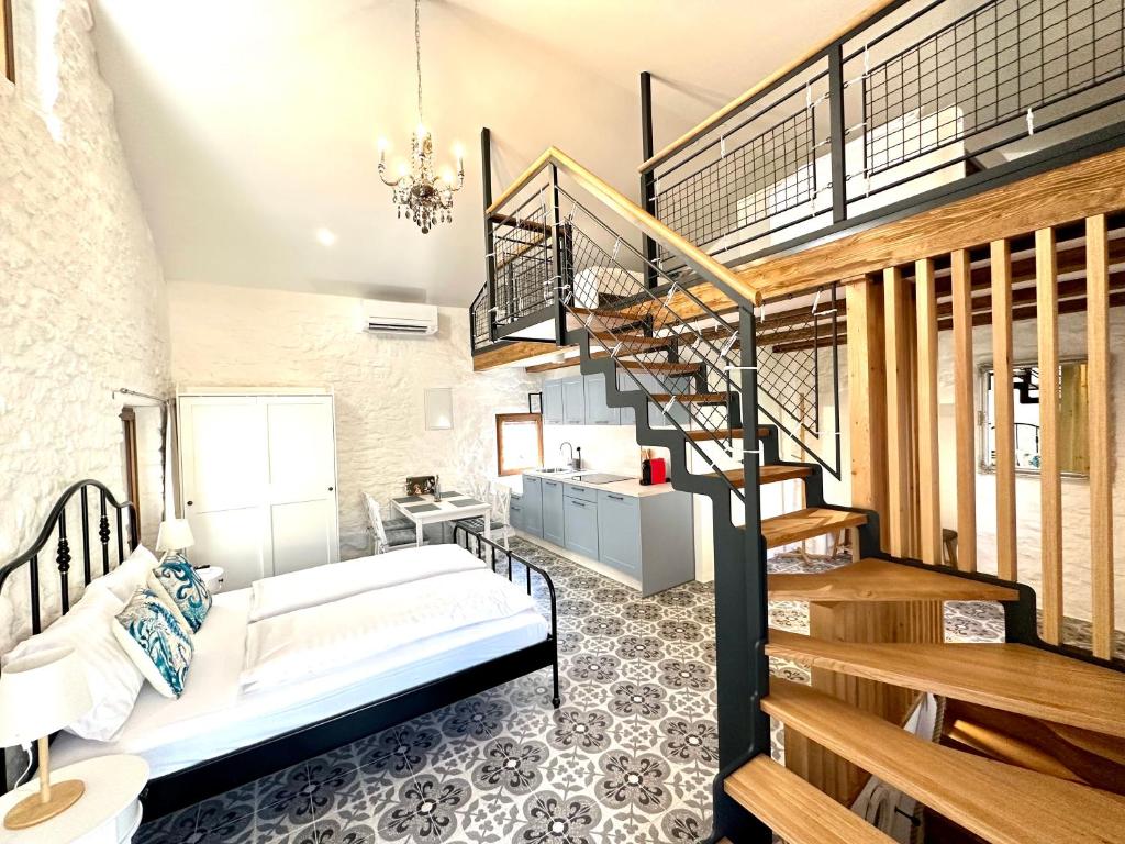 a bedroom with a bed and a spiral staircase at Apartments Angela in Piran