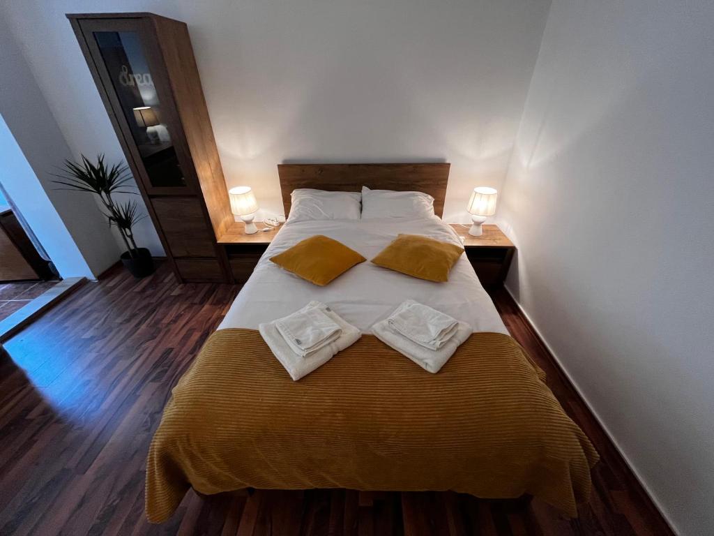 ein Schlafzimmer mit einem Bett mit zwei Handtüchern darauf in der Unterkunft Cozy Flat in Braşov