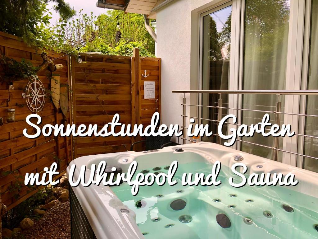 una bañera en un jardín con las palabras "sándwich en el jardín" no se puede comer en GartenApartment Strandgut mit Outdoor Whirlpool und Garten en Petershagen