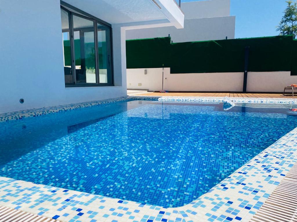 - une piscine dans une maison revêtue de carrelage bleu dans l'établissement Villa Anita features privacy, sea views and private pool, à San Roque