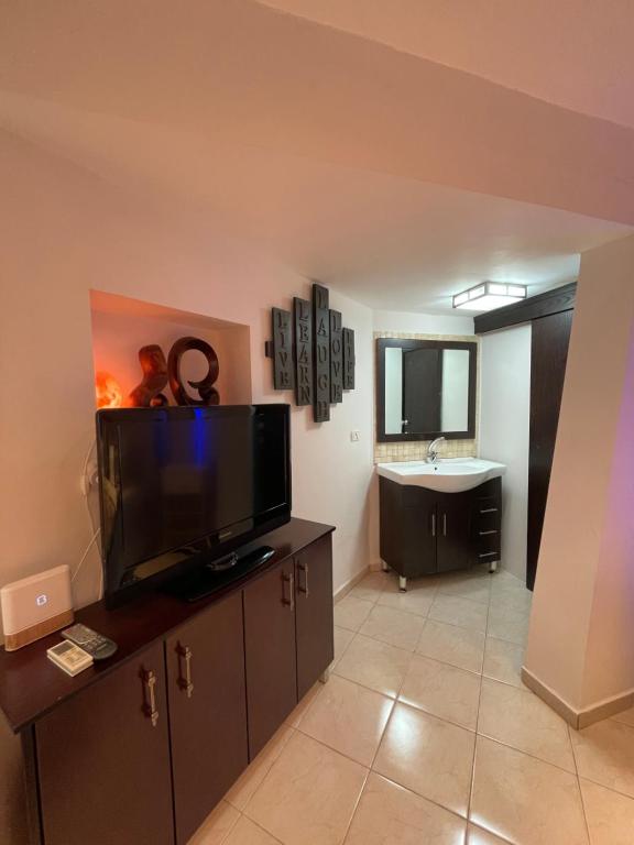 a living room with a flat screen tv and a bathroom at Eilat Beach House in Eilat