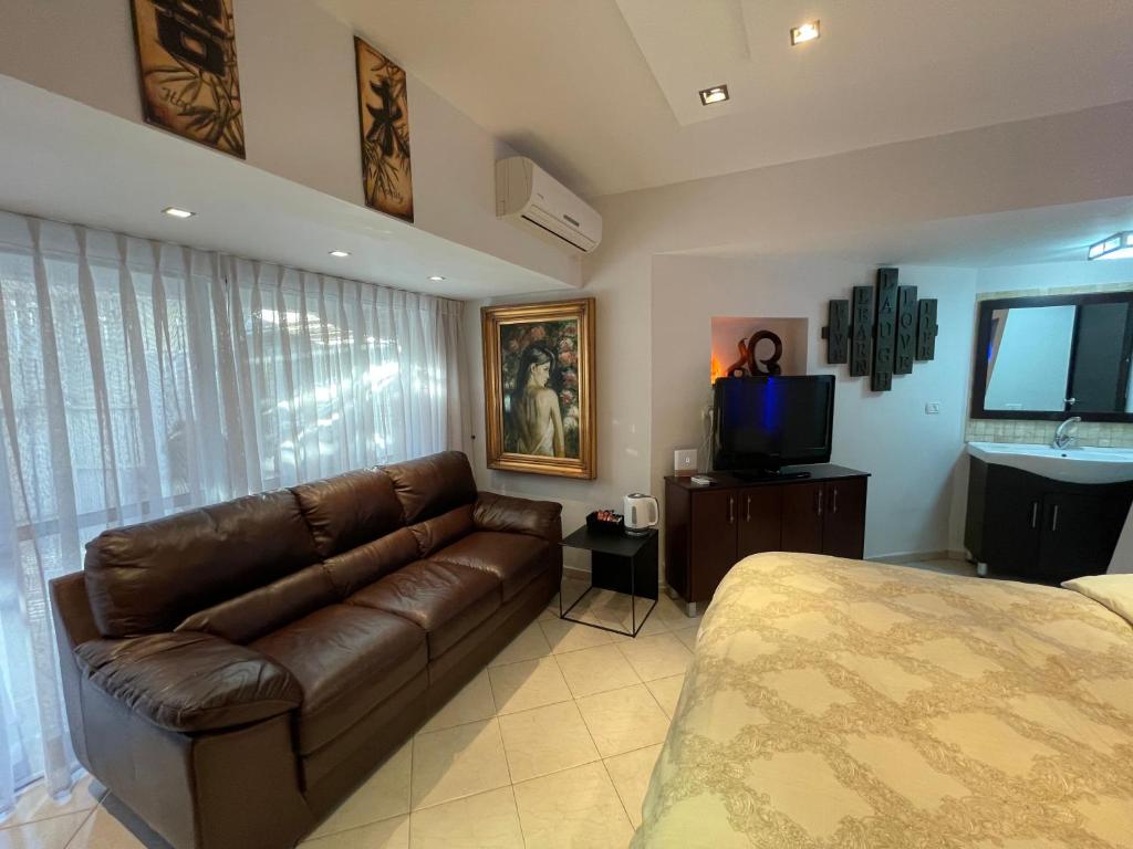 a living room with a couch and a television at Eilat Beach House in Eilat