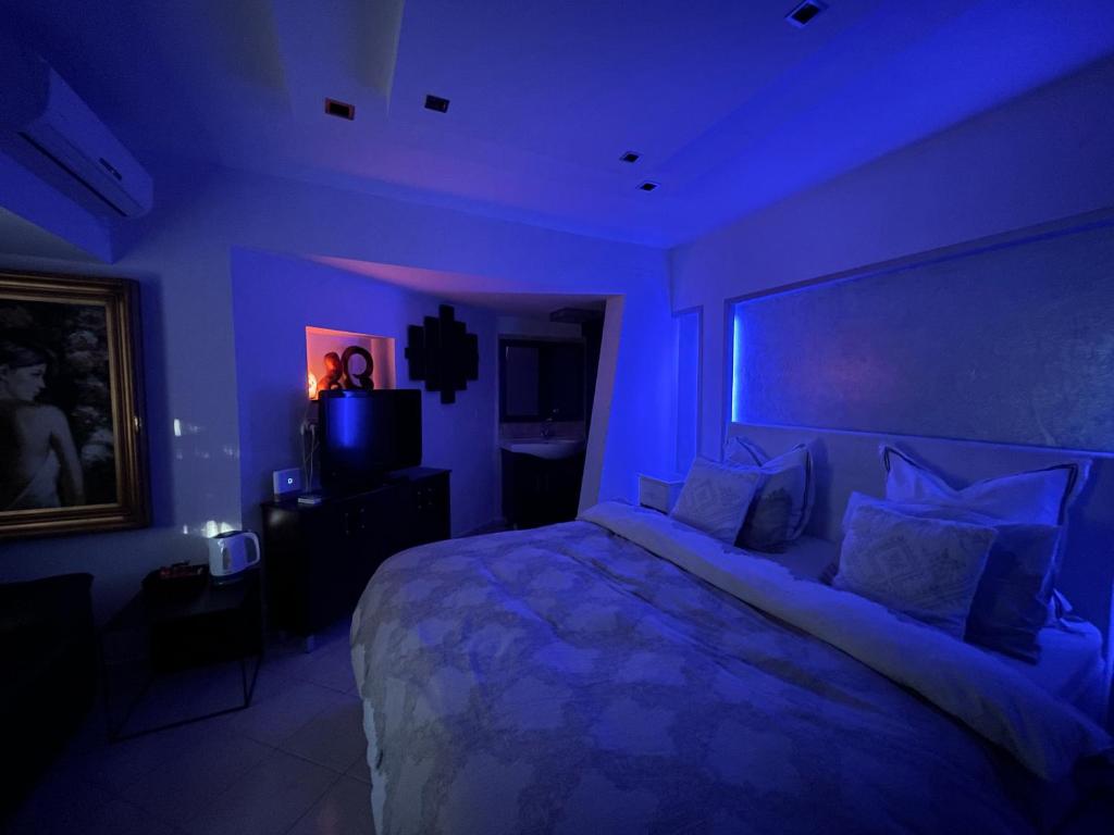 a blue room with a bed and a television at Eilat Beach House in Eilat