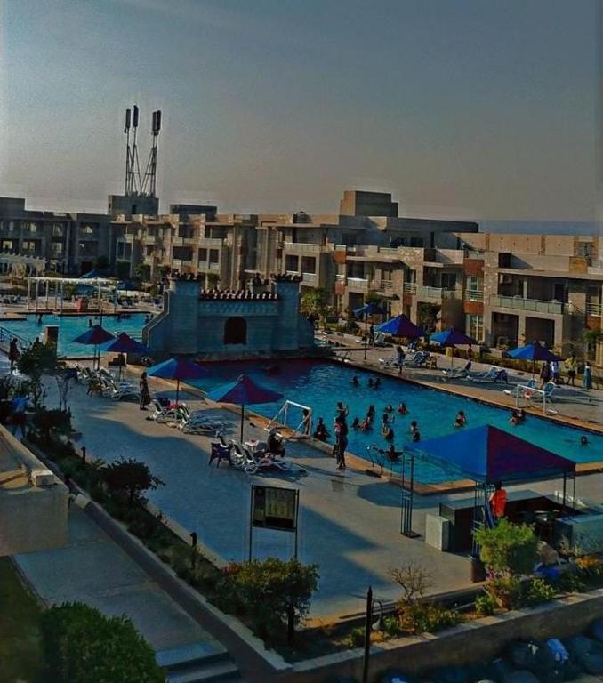 a large swimming pool in a city with people in it at شاليه فندقي بحمام سباحه خاص داخل فندق ايليت ريزيدنس اند اكوا بارك in Ain Sokhna