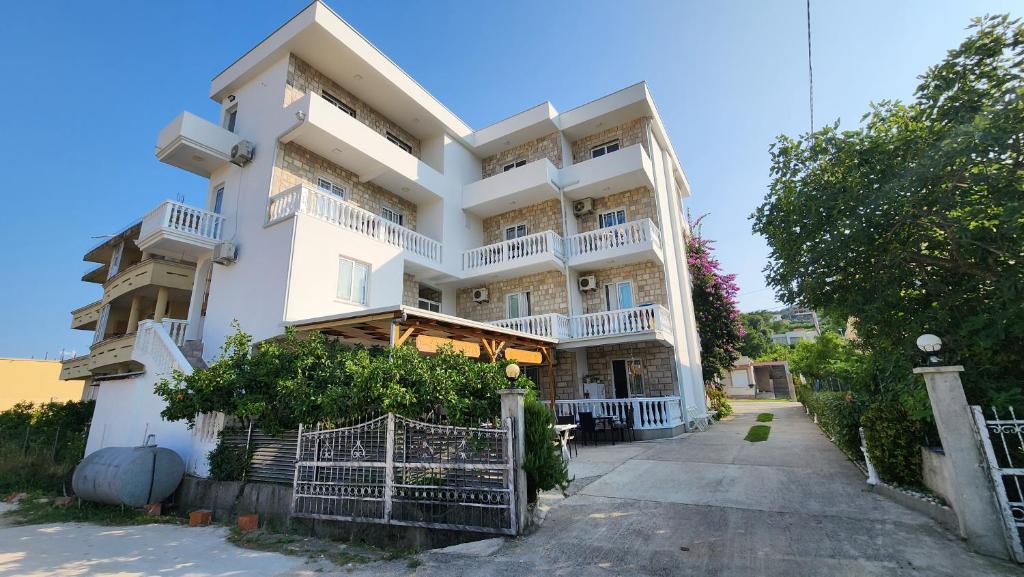 a large white building with balconies on it at Apartments Cota Guesthouse in Ulcinj