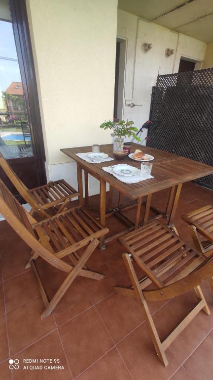 een houten tafel met twee stoelen en een tafel met een plant bij La CASUCA De TINA in Prellezo