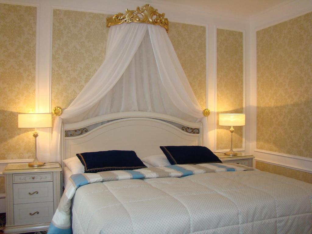 カルロヴィ・ヴァリにあるホテル サンクト ペテルブルクのベッドルーム(天蓋付きの白い大型ベッド1台付)