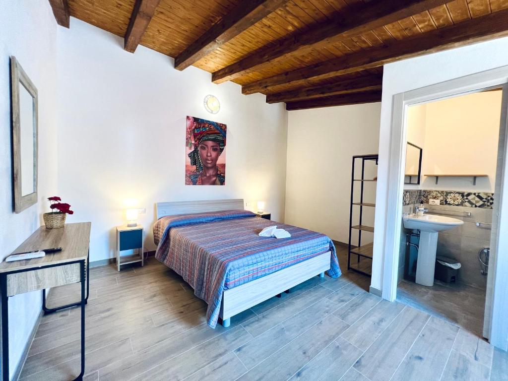a bedroom with a bed and a sink at Amuri in Cinisi