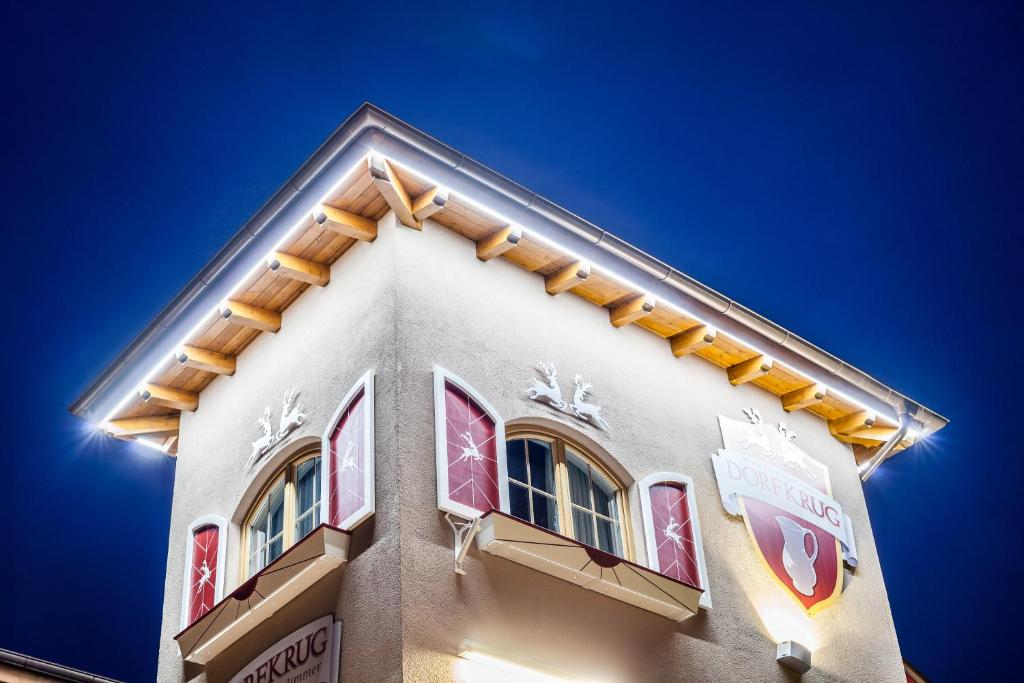 Dorfkrug Kaprun - Luxury Suites & Appartements by SFL في كابرون: مبنى طويل وبه نوافذ وسماء زرقاء
