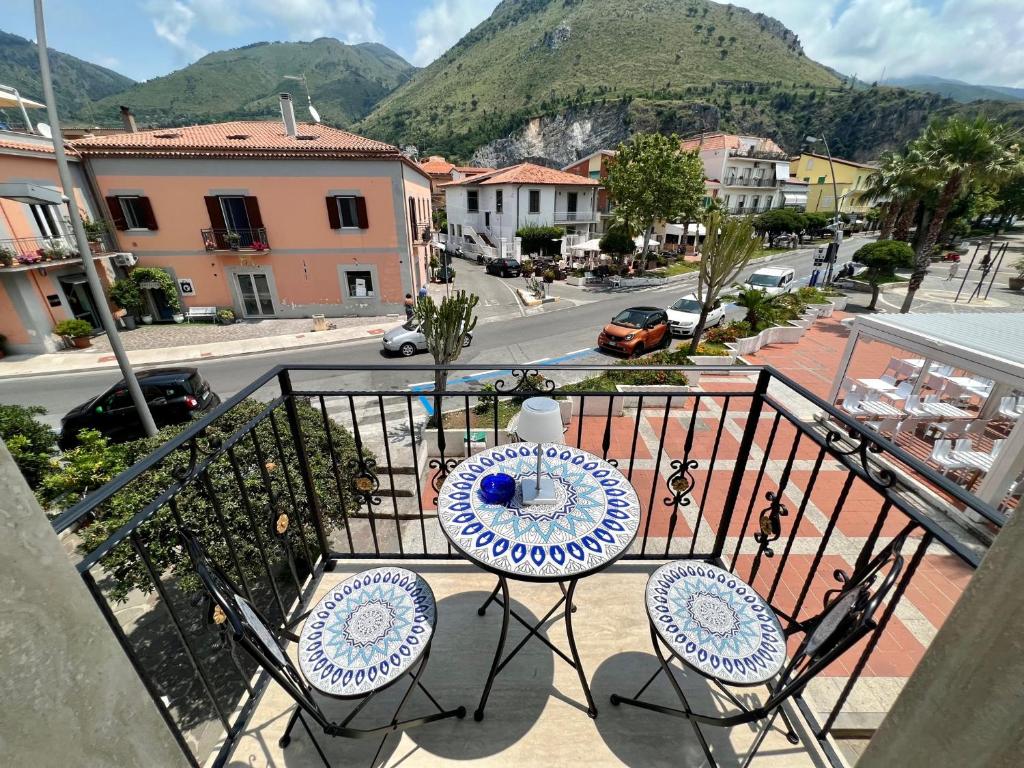 einen Tisch und Stühle auf einem Balkon mit Straßenblick in der Unterkunft TEA Luxury - Praia a Mare in Praia a Mare