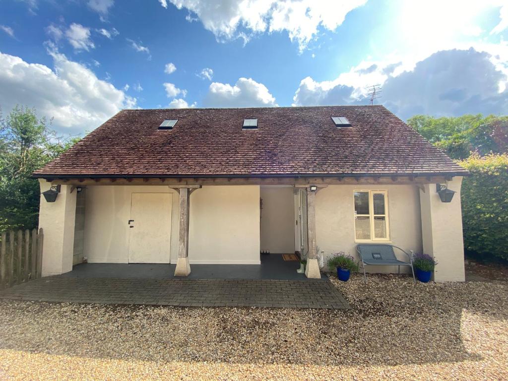 a small white house with a roof and a porch at Inkwell in Chippenham