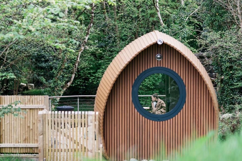 a person in a dog house with a mirror at RiverBeds - Luxury Wee Lodges with Hot Tubs in Glencoe