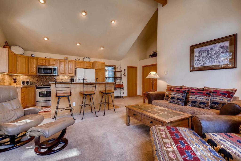 a living room with a couch and a table at Beautiful Mountain Townhome with Private Hot Tub, Steps from Everything Breckenridge! HL305 in Breckenridge