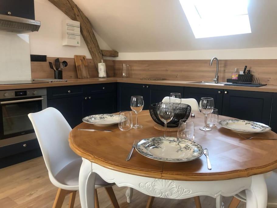 eine Küche mit einem Holztisch mit Weingläsern darauf in der Unterkunft Le Domremy F2 au cœur d'Orléans in Orléans