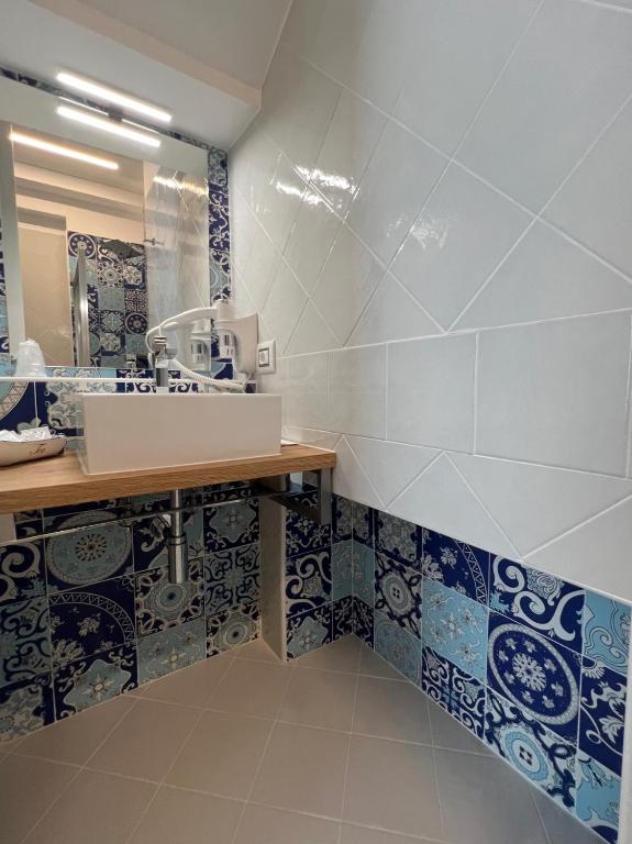 a bathroom with a sink and blue and white tiles at TEA Luxury - Praia a Mare in Praia a Mare