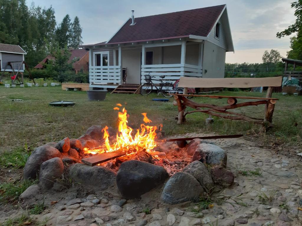 a fire pit in front of a house with a bench at Letni Spokój in Worliny