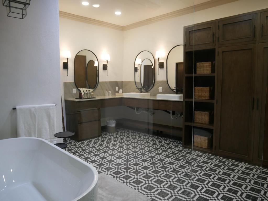 La salle de bains est pourvue d'une baignoire, de deux lavabos et de miroirs. dans l'établissement Hotel El Farol, à Parras de la Fuente