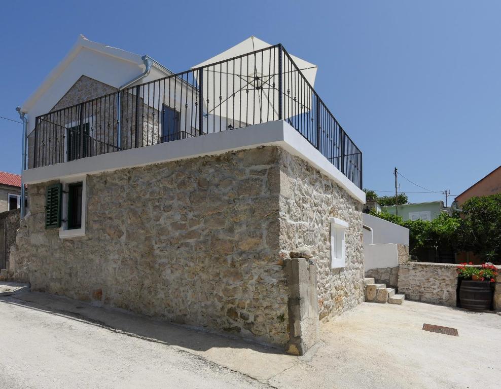 a stone building with a balcony on top of it at Holiday Stone House - Fumarea in Rtina