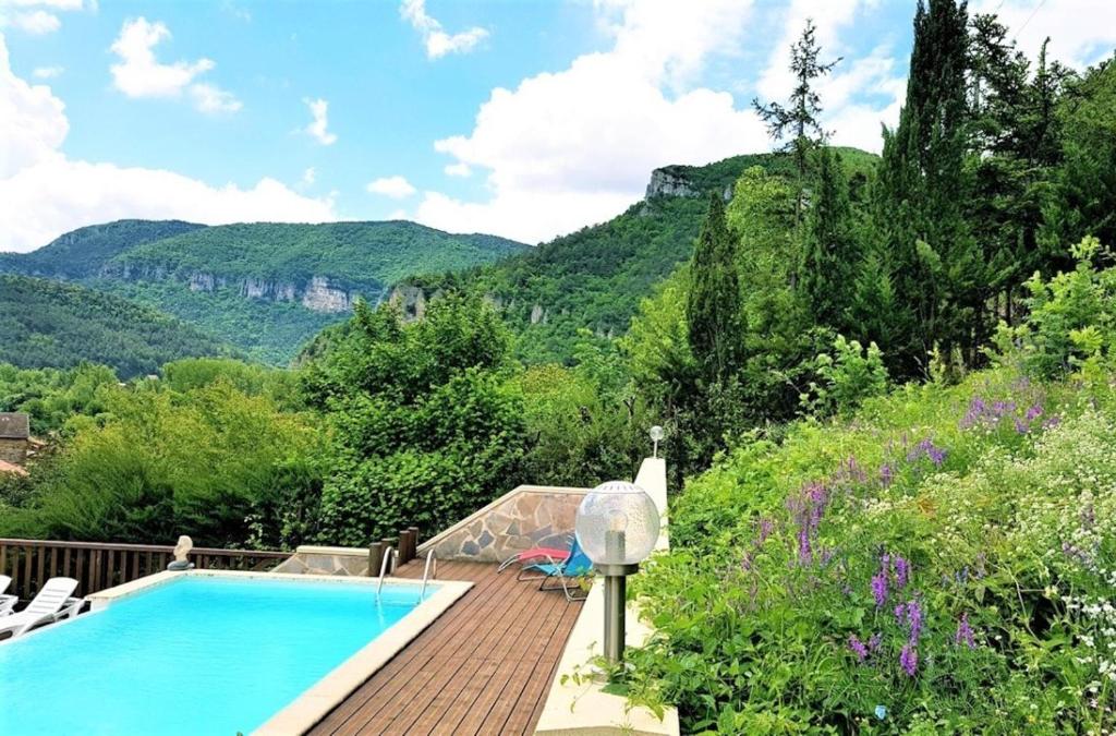 a swimming pool with a view of the mountains at Les GARGOUILLES Gorges du Tarn - Millau in Boyne