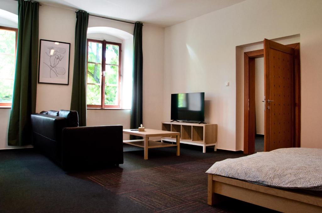 a living room with a bed and a television at Elephants Apartments in Bratislava