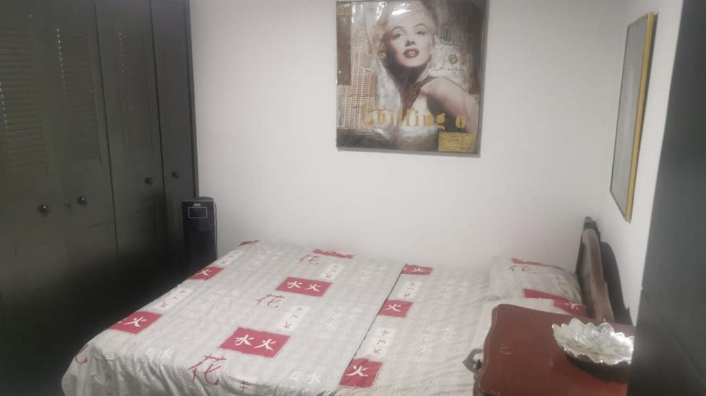 a bed in a room with a poster on the wall at WALOJO¡ Acogedor Apartamento, Excelente ubicación in Neiva