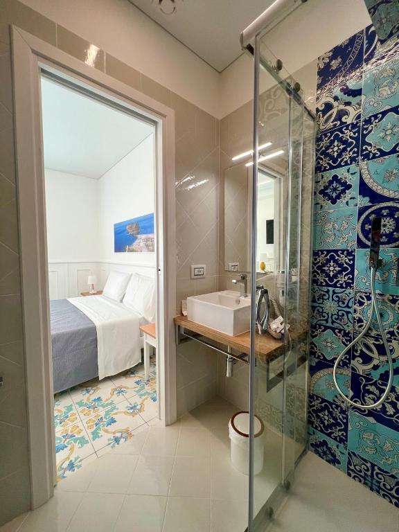 a bathroom with a shower and a bed and a sink at TEA Luxury - Praia a Mare in Praia a Mare