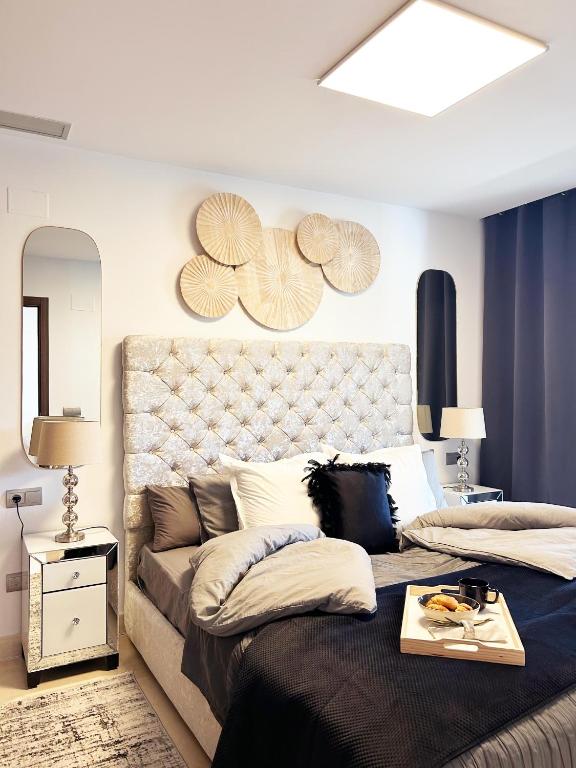 - une chambre avec un grand lit et une grande tête de lit dans l'établissement Maribel Apartamento Moderno, à Marbella