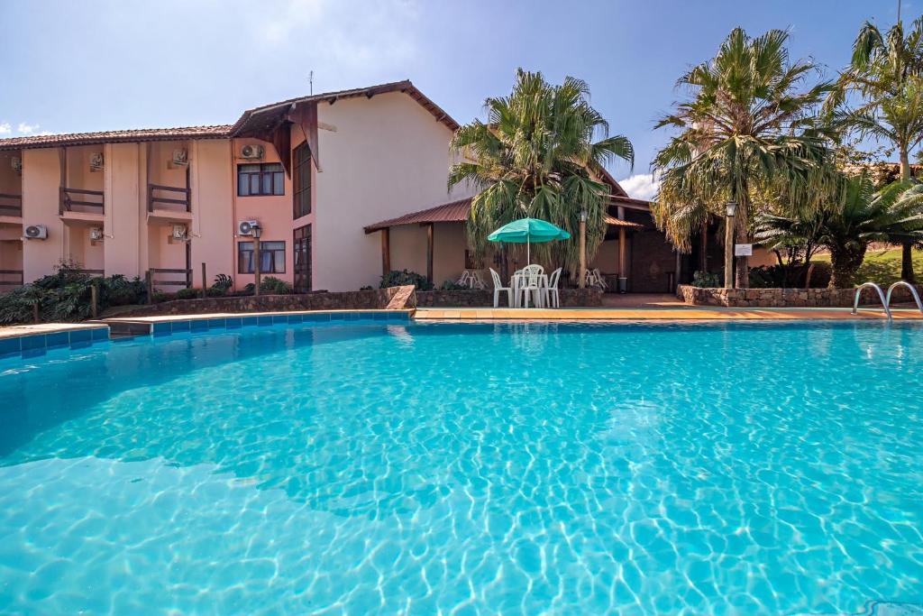 a large swimming pool in front of a house at Hotel Vivenda das Cachoeiras in Brotas