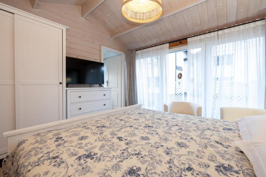 1 dormitorio con 1 cama grande y TV en Dom Goscinny "Marta", en Dziwnówek