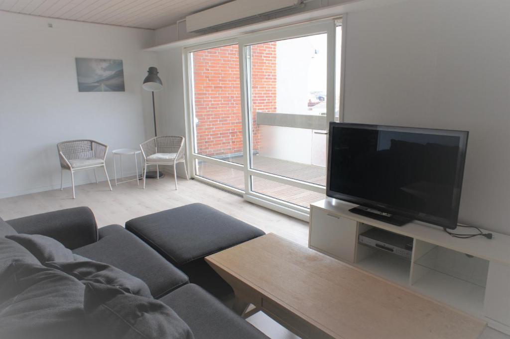 a living room with a couch and a flat screen tv at Vesterhavsgade 47. door 25 (id. 076) in Esbjerg