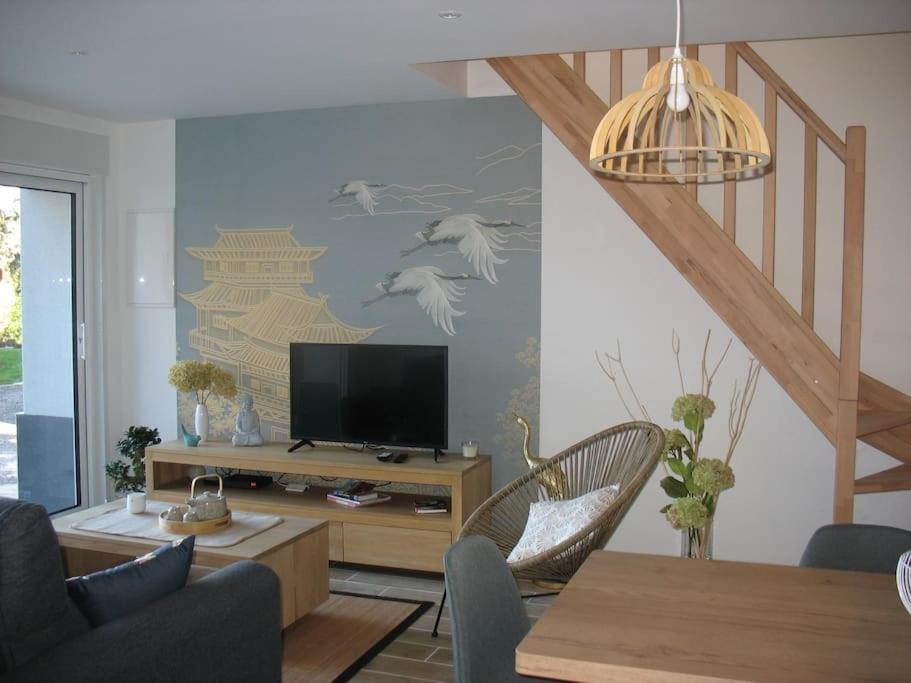 ein Wohnzimmer mit einem TV und einer Treppe in der Unterkunft Gite le Ryokan in Wailly-Beaucamp