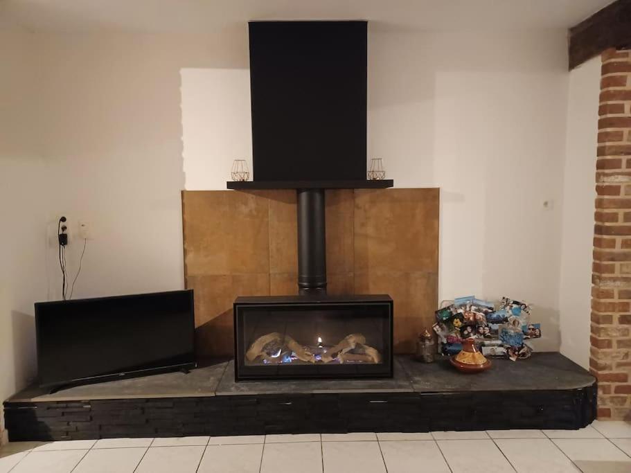 a fireplace with a stove in a room at House close to the city center in Mons