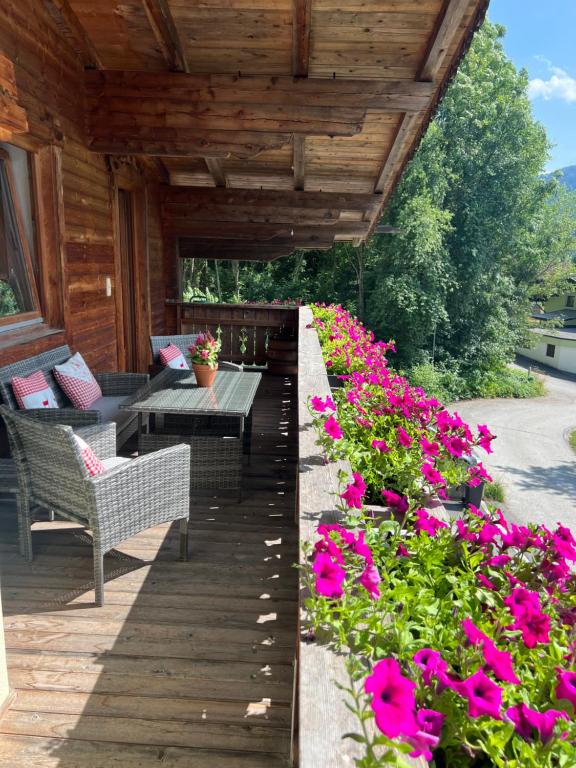 斯圖姆的住宿－Ferienwohnung Gamsbock Panorama View Balkon, Gartensauna, Garten, Grillplatz，庭院里种着粉红色的鲜花,配有桌子和长凳