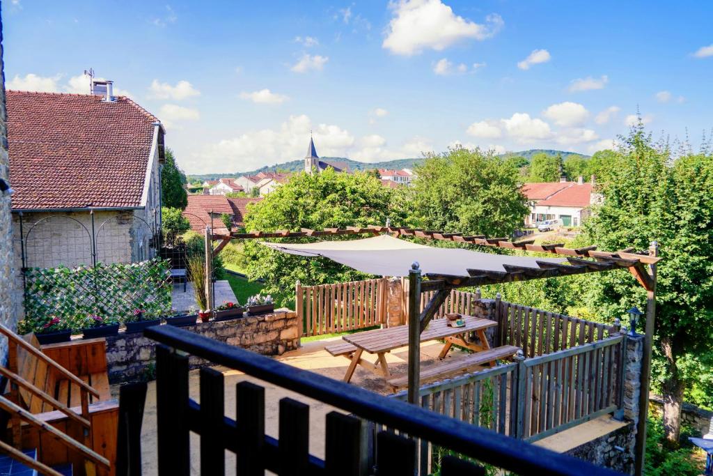 a wooden deck with an umbrella and a table at Maison Ainvelle - with Sauna in Ainvelle