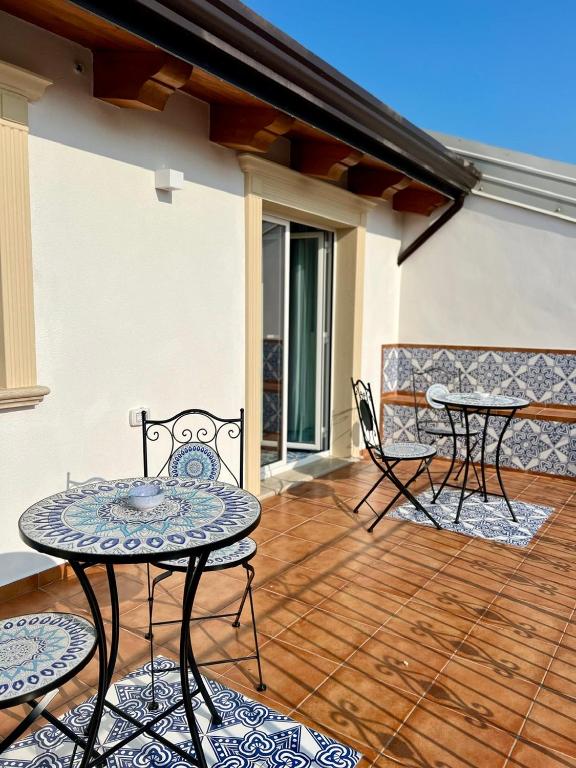a patio with two tables and chairs on a deck at TEA Luxury - Praia a Mare in Praia a Mare