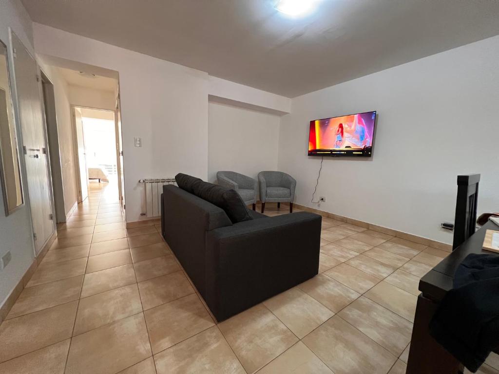 a living room with a couch and a tv on the wall at Hermoso Depto para 4 o 6 personas in Salta