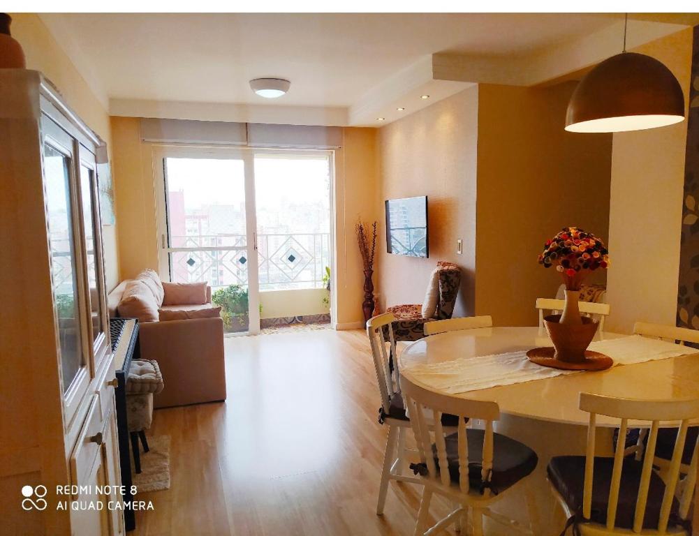 a living room with a table and a couch at Apartamento moderno com 03 quartos e 02 garagens in Campinas