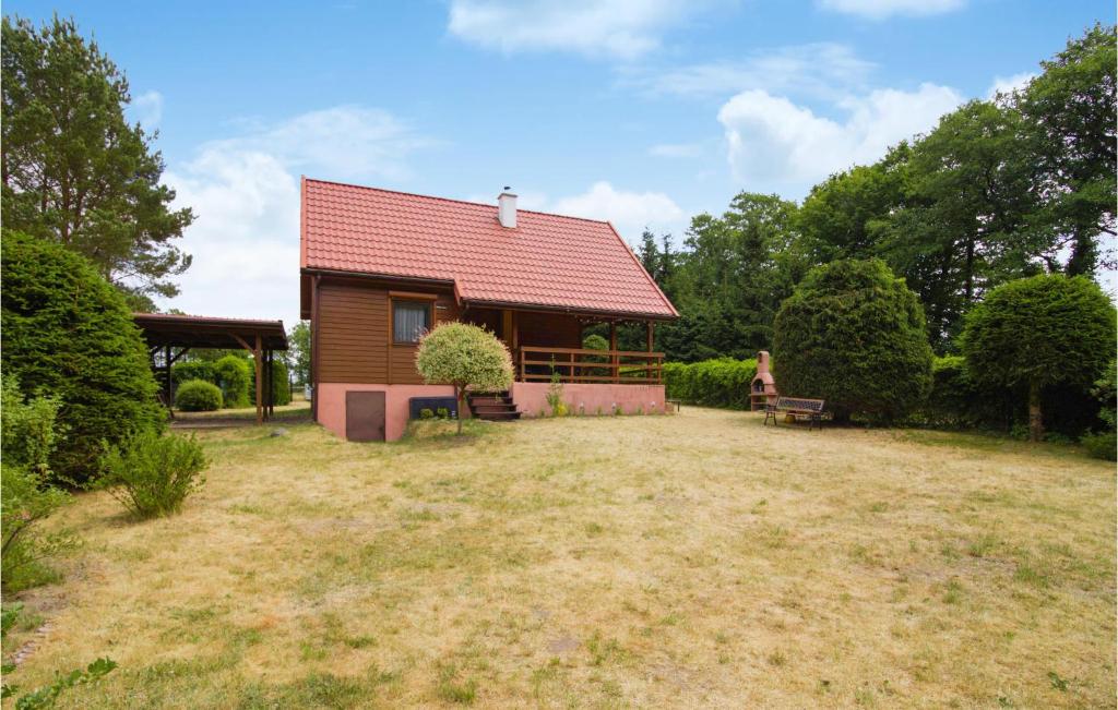 una pequeña casa con techo rojo en un patio en Cozy Home In Morag With Lake View, en Morąg