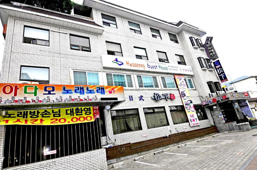 un bâtiment avec des écrits asiatiques sur son côté dans l'établissement Hwaseong Guesthouse, à Suwon